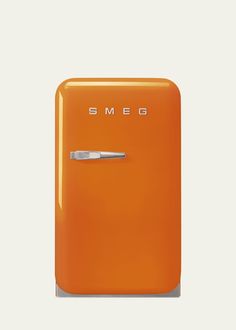 an orange refrigerator with the word smeg on it's front and bottom door