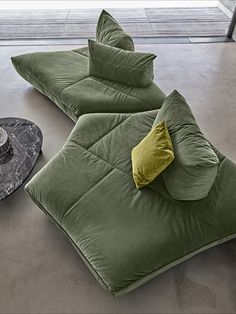 two green bean bags sitting on top of a floor next to a black round object