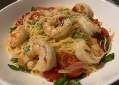 a white plate topped with pasta and shrimp