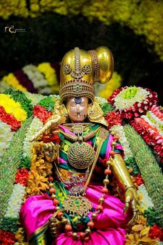 the statue is decorated with flowers and gold