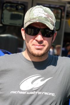 a man wearing sunglasses and a camo hat