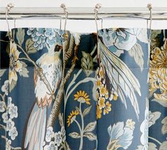 the curtains are decorated with blue and yellow florals, including a bird on a branch