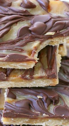 several pieces of chocolate - covered cookie bars stacked on top of each other with one bite taken out