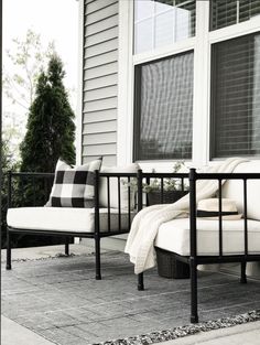 a white couch sitting on top of a patio next to a window