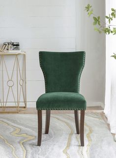 a green chair sitting on top of a rug in front of a white wall and floor