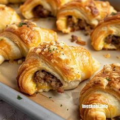 several pastries with meat and cheese are on a baking sheet, ready to be eaten