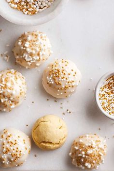 some white and gold sprinkles are on the table next to small bowls