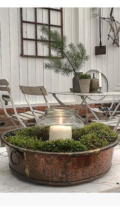 a candle is lit in a potted planter on the ground near some chairs