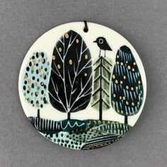 a ceramic ornament with trees and birds on it