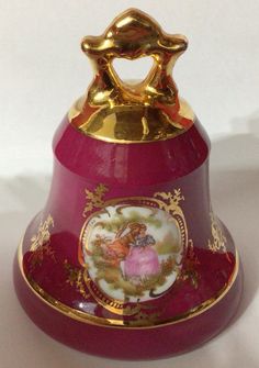 a red and gold bell with an angel on it