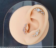 a pair of ear piercings sitting on top of a fake headpiece in a display case