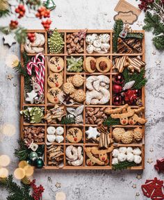 a wooden box filled with lots of different types of cookies and other holiday treats on top of a table