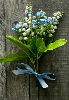 blue and white flowers tied to a wooden fence