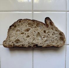 a piece of bread sitting on top of a white tile wall