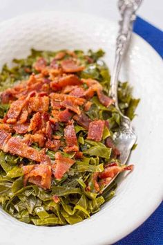 a white bowl filled with lettuce and bacon on top of a blue table cloth