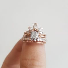 a person's hand holding a ring with two diamonds on it and the middle finger