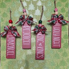 three red and green wooden signs with christmas decorations on them