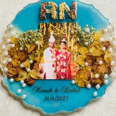 a blue plate with an image of a bride and groom in the middle surrounded by leaves