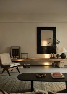 a living room filled with furniture and a painting on the wall above it's coffee table