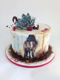 there is a cake decorated with a horse and succulents on the top