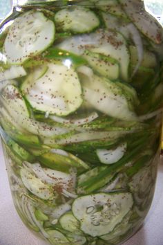 a jar filled with sliced cucumbers on top of a table