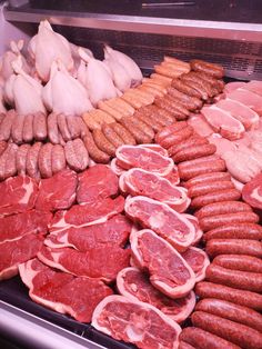 an assortment of meats and sausages on display