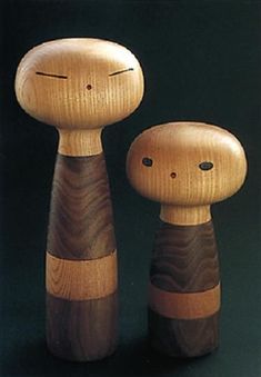 two wooden dolls sitting next to each other