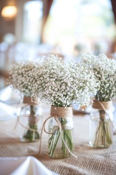 three mason jars filled with baby's breath flowers