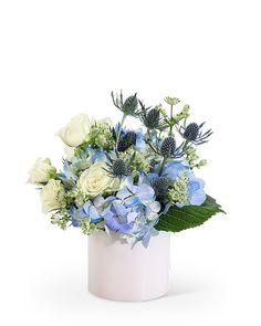 a white vase filled with blue and white flowers