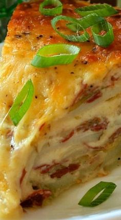 a piece of lasagna on a white plate with green garnishes