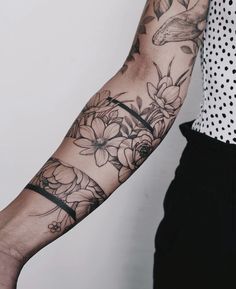 a woman's arm with flowers and a bird tattoo on her left arm, next to a polka dot shirt