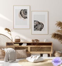 two framed pictures hang on the wall above a wicker chair and table with flowers