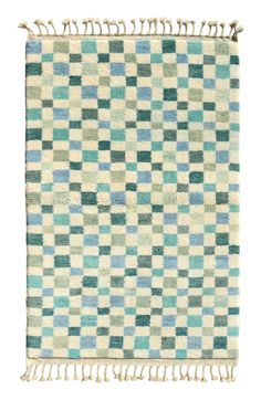 a green and blue checkered rug with fringes on the bottom, in front of a white background