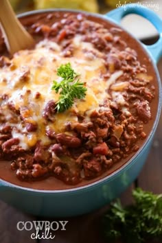 a blue pot filled with chili and cheese