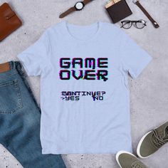 a t - shirt with the words game over printed on it next to jeans and shoes