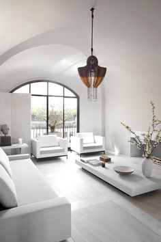 a living room with white furniture and large windows