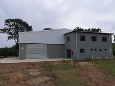 a large gray building sitting on top of a dirt field