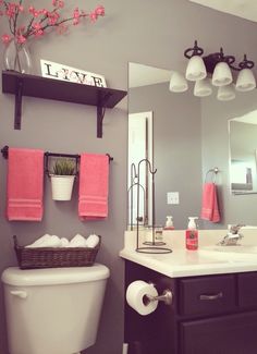 a white toilet sitting under a bathroom mirror next to a sink and a bath tub