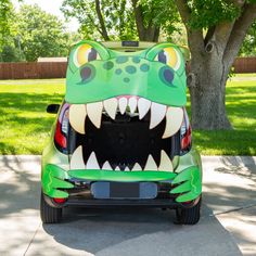 the back end of a green car with an alligator face painted on it's trunk