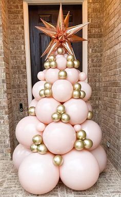 a christmas tree made out of balloons in front of a door with a star on top