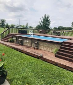 an above ground pool with steps leading up to the deck and table next to it