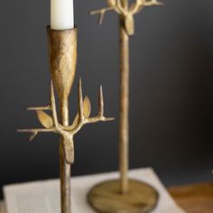 two metal candlesticks sitting on top of a table