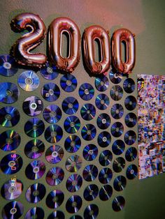 balloons and cds are arranged in the shape of an ovoid with the number 2000 on it