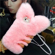 a woman holding a pink furry case with diamond buttons on the front and back side