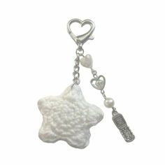 a white key chain with a star and heart charm on it's end, hanging from a metal hook