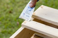 a person holding a piece of wood with a tag on it