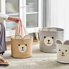 a woman sitting on the floor with four baskets in front of her and one holding a bag