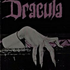 a hand reaching over the edge of a wall with words dracula written on it in black and white