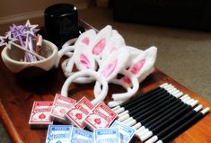 a wooden table topped with lots of different types of pens and eraser sets on top of it