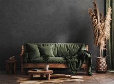 a living room with a green couch and rugs on the floor next to a wooden coffee table